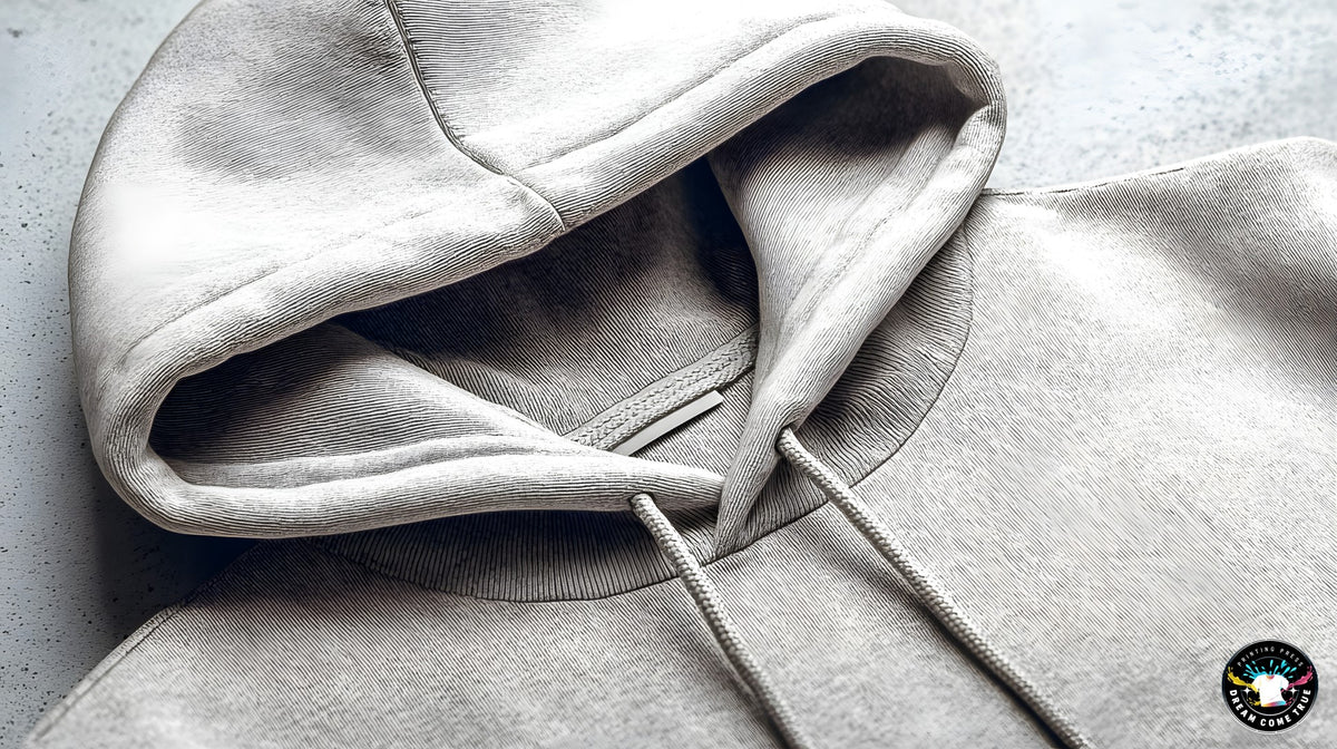 Close-up of a gray hoodie with a brand logo in the corner at D.C.T Printing Press in Texas.